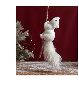 Detailed view of plush white Christmas squirrel ornament on snowy wooden surface