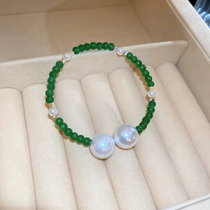 Detail of vintage beaded bracelet with emerald green beads and pearls in a velvet box