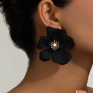Detail of large black matte petal earrings with gold stamen and sparkling rhinestones