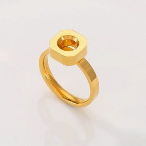 Macro view of golden square ring with circular cutout and brushed metal texture