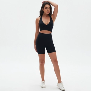 Dettaglio dei pantaloncini yoga neri a vita alta e reggiseno sportivo con scollo a V