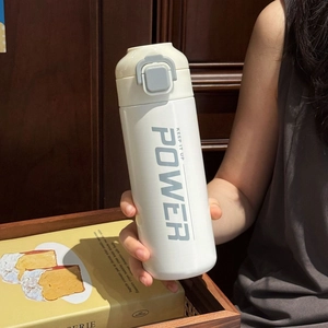 Close-up of white insulated sports bottle with pop-top lid held in hand by a person