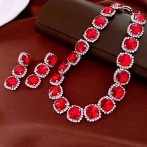 Detailed view of vintage jewelry set with red round crystals and silver rhinestone accents