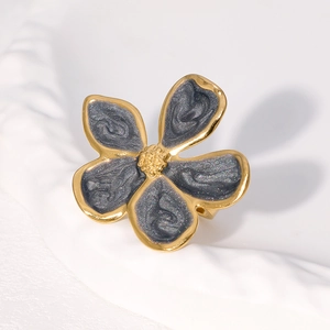 Détail d'une bague vintage en acier inoxydable avec émail gris et design floral doré