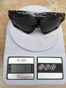 Lightweight 36g black sports sunglasses showing aerodynamic design on a digital scale