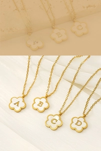 Detailed macro view of four leaf clover necklaces with 18K gold plating and alphabet initials