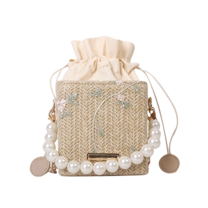 Straw bucket bag with floral embroidery and elegant pearl handle for women