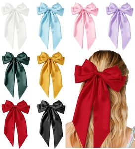 Detail view of large satin bow hair clips in eight colors with long elegant streamers