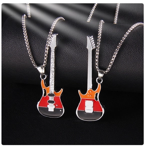 Gros plan de pendentifs guitare avec émail coloré sur un fond noir texturé