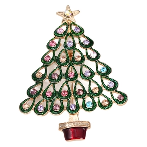 Elegant gold Christmas tree brooch with green enamel and colorful rhinestones on white background