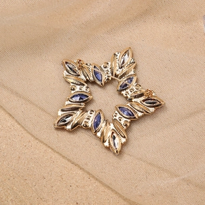 Back view of gold star brooch showing pin fastener and colorful marquise rhinestones