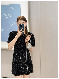 Chic silver conch shell crossbody bag with pearl chain paired with black sequin dress