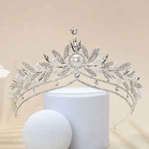 Detailed close-up of a silver bridal crown with white pearls and sparkling rhinestones