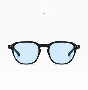 Detail of square black sunglasses with light blue lenses and silver metal rivets decoration