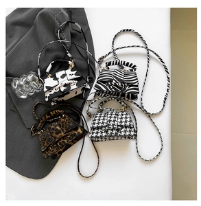 Detail of mini trapezoid crossbody bags in cow, zebra, leopard and houndstooth patterns