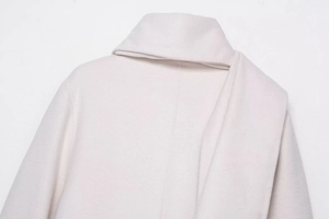 Close-up of the elegant lapel and wool blend texture on this beige winter coat