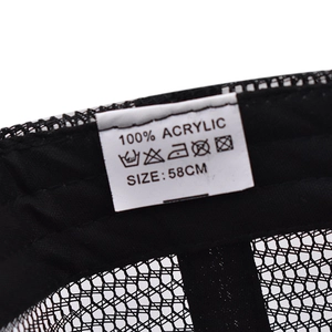 Close-up of the wash label on a black mesh baseball cap showing 100% acrylic material
