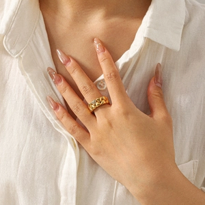 Detail of 18k gold heart ring with pavé diamonds worn on finger for casual styling