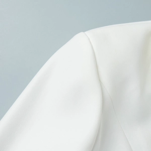 Macro shot of white blazer shoulder featuring high-density twill fabric and neat stitching
