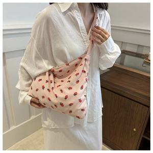 Detailed close-up of pink corduroy fabric and strawberry pattern on a tote bag