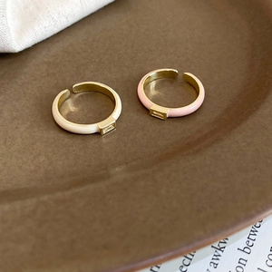 Detailed macro view of square zircon gold open rings with pink and white enamel finish