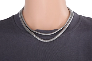 Gros plan d'un collier chaîne serpent en argent porté par un mannequin au cou