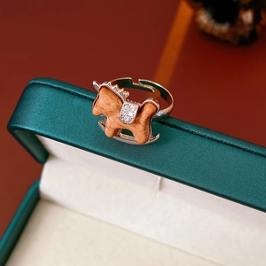 Macro detail of silver rocking horse ring with wood texture and zircon inlay on velvet