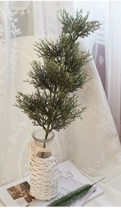 Realistic artificial green pine branches in a decorative woven vase for Christmas decor