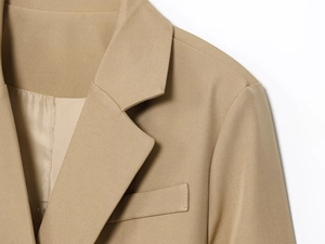 Detail of khaki blazer lapel and shoulder showing high-quality twill fabric texture