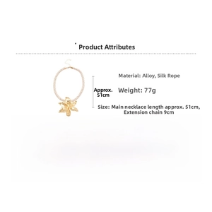 Detail showing gold floral pendant and cream woven silk rope with specific sizing information