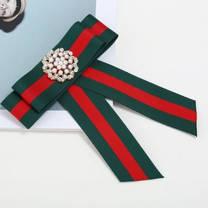 Vintage red and green striped ribbon bowtie brooch with central pearl rhinestone detail