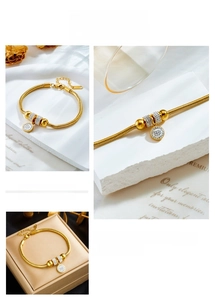 Close-up of gold snake chain bracelet with pavé cubic zirconia charms and pendant