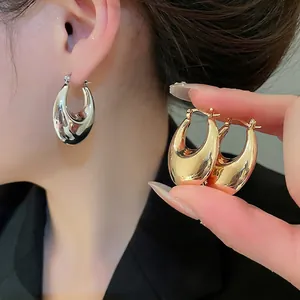 Minimalist glossy oval hoop earrings in polished gold and silver finish for women