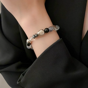 Minimalist black gallstone and crystal beaded bracelet for women on black suit sleeve