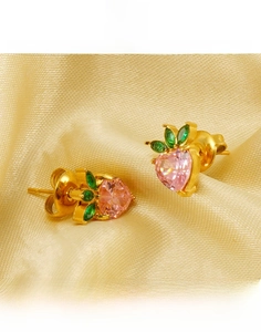 Close-up of pink heart-shaped titanium steel studs with green leaves on silk cloth