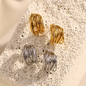 Abstract woven line 18K gold and silver plated earrings on white stone display