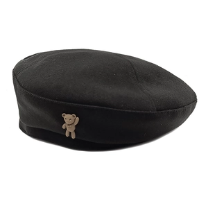 Women's black wool beret hat with a cute brown bear accessory in a minimalist style