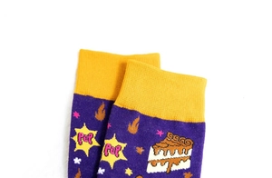 Détail de chaussette en coton violet avec revers jaune et motifs de gâteau et pop