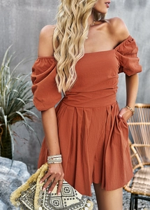 Detail view of orange off-shoulder jumpsuit with puff sleeves and ruched texture