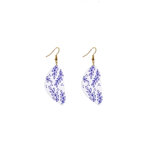 Detail of blue and white porcelain pattern on acrylic leaf earrings with gold hooks