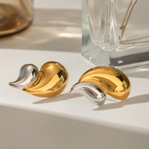 Macro shot of two-tone gold and silver shell-shaped earrings with polished finish
