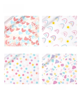Macro detail showing four pastel patterns including rainbow, dots and heart shapes for gift wrap