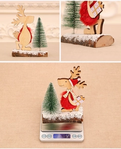 Detail of wooden Christmas reindeer figurine and pine tree on a snowy base