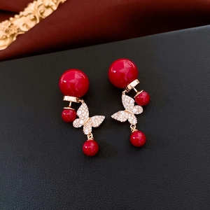 Vue détaillée de boucles d'oreilles papillon plaquées or 18 carats sur cuir noir chic