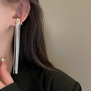Close-up of silver tassel ear cuff with long snake chain fringe on a model ear