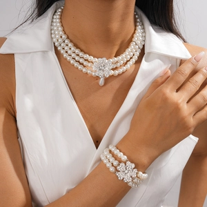 Detail of baroque pearl necklace set with crystal floral clasp and droplet pendant