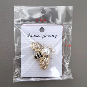 Detailed view of elegant rhinestone bee brooch in packaging showing 5.5x7cm dimensions