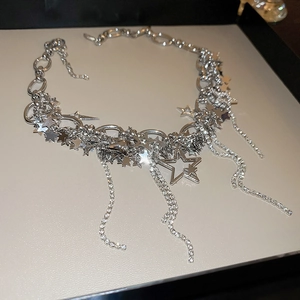 Detailed view of silver star tassel necklace with sparkling rhinestones on black background
