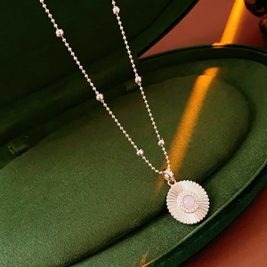 Gros plan du pendentif marguerite en argent avec pierre rose en boîte velours