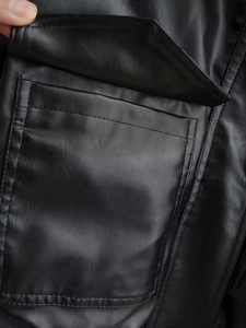 Close-up of side pocket and stitching on a black faux leather jacket for women